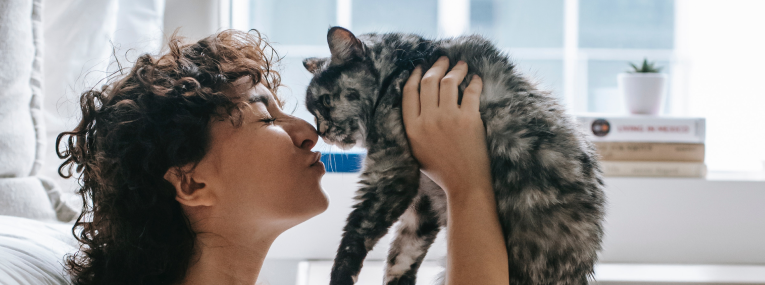 Ein Frauchen schmust mit ihrer Katze.